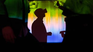 A colorful shadow of a man wearing a VR headset